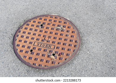 A Top View Image Of A Rusted Metal Storm Drain Cover.