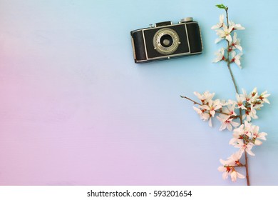 top view image of spring white cherry blossoms tree next to old camera on wooden background