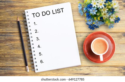 Top view image of text TO DO LIST on blank notebook and cup of coffee on wooden table background - Powered by Shutterstock