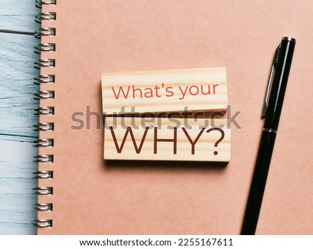 Top view image text what is your why written on wooden blocks with notebook and a pen on the table.