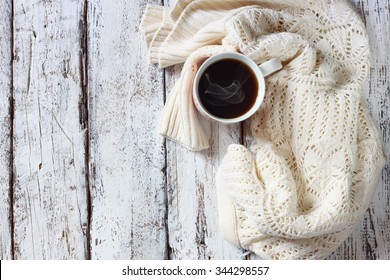 Top View Image Of White Cozy Knitted Sweater With To Cup Of Coffee On A Wooden Table 