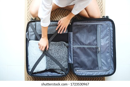 Top view image of a woman packing luggage for a trip