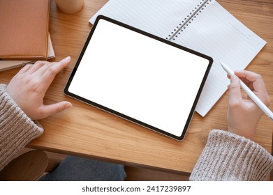 Top view image of a woman using a digital tablet at her desk. A white-screen digital tablet mockup on a wooden desk. people and technology concepts - Powered by Shutterstock