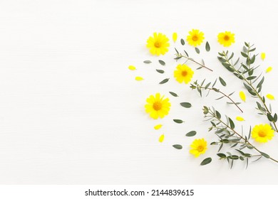 Top view image of yellow chrysanthemum field flowers composition over wooden white background. Flat lay - Shutterstock ID 2144839615