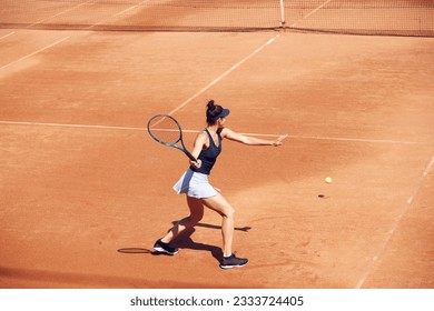 Top view image of young woman, tennis player in motion during game at open air tennis court. Serving ball. Concept of sport, hobby, active lifestyle, health, endurance and strength, ad - Powered by Shutterstock