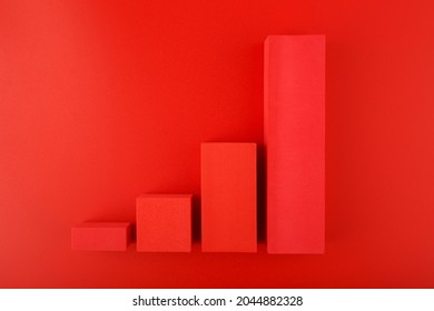Top view of increasing chart made of red blocks on red background. Concept of business, sales and increasing dynamics