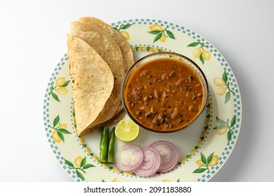 Top View Of Indian Meal Vegetable Dal Makhni Chapati Or Roti Or Indian Bread With Slice Of Onion Lemon And Green Chili Serve In Plate On White Background 