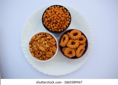 Top view of Indian and pakistani snack food item cuisine Namkeen mixture boondi ring crunchy crispy snacks served in white plate isolate in white background.Spicy mix of fried items for tea time snack