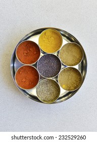 A Top  View Of An Indian Spice Box With Multiple Containers.