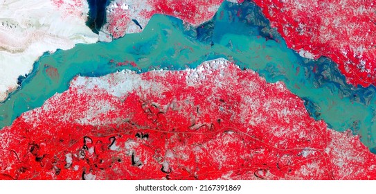Top view of Indus River, Manchhar Lake, flooded fields, satellite image, red vegetation, turquoise blue waters, aerial photo of earth, Pakistan’s largest lake. Elements of this image furnished by NASA