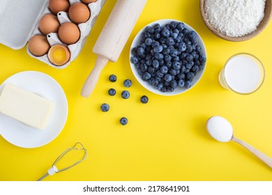 Top View Of Ingredients For Making Blueberry Pie Or Cake On The Yellow Background. Copy Space.