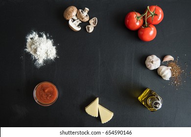 Top View Of Ingredients For Preparing Italian Pizza On Dark Surface