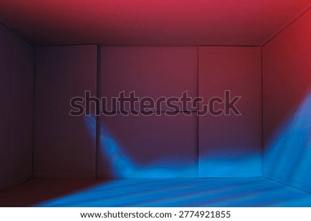 Top view inside open empty cardboard box, lit by color lights