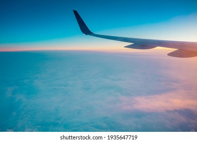 Top view from inside window airplane of a sunset sky and wing