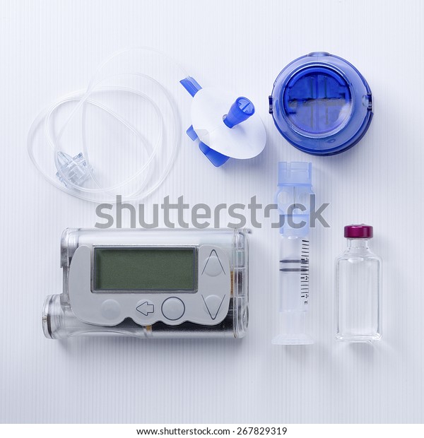 top view of an insulin pump set background\
consisting of: an insulin pump, insertion system of the infusion\
set, a reservoir of an insulin pump, insulin vial and a infusion\
set on a white background