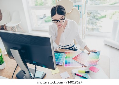 Top View Of Intelligent Stylish Young Asian Graphic Designer Is Working With Colors Samples, Pensive. She Is A Successful Self Employed Artist