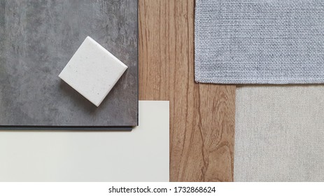 top view of interior finishing material combination containing wooden and concrete vinyl tiles ,white laminate , grey fabric ,grey interior wallpaper and synthesis stone samples. - Shutterstock ID 1732868624