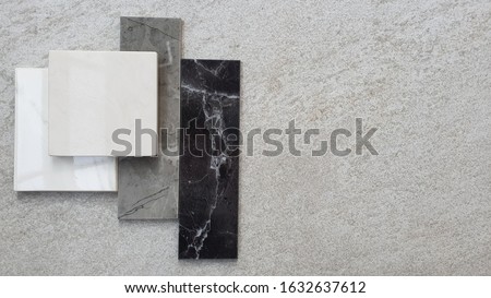 top view of interior stone tile samples material on cement background. the samples of marble stone place on grey stone background with space for text.