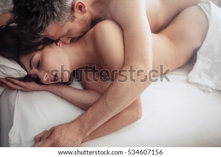 Top view of intimate lovers making love in bed. Romantic and passionate young couple on bed having sex.