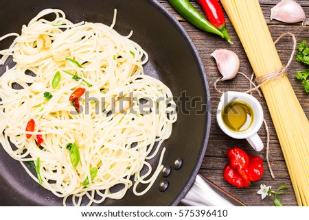  Top View Italian Dish with Raw Cooking Ingredients on Wooden Background. Spaghetti Aglio Olio e Peperoncino on Roasting Pan.