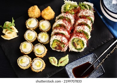 Top View Of Japanese Sushi Set With Panko Fried Rolls And Vegan Rolls With Shiitake Mushroom And Vegetables On Black Board