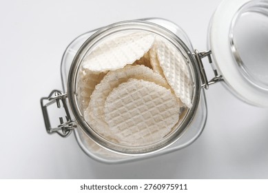 Top view of a jar of thin, crispy traditional wafers known as simping in Indonesia.