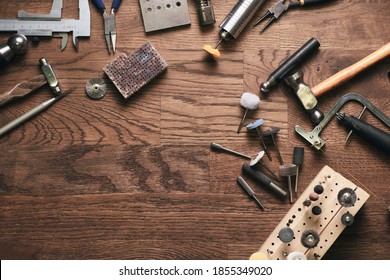 Top view jewelry maker workbench with tools on table. Equipment and tools of a goldsmith on wooden working desk inside a workshop. - Powered by Shutterstock