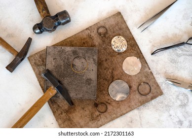 Top view jewelry maker workbench with tools on table. Equipment and tools of a goldsmith on wooden working desk inside a workshop. - Shutterstock ID 2172301163