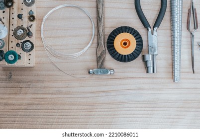 Top View Jewelry Maker Workbench With Tools On Table. Equipment And Tools Of A Goldsmith On Wooden Working Desk Inside A Workshop.