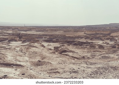 Top view to the Judaean desert and the Dead Sea. The desert land of Israel. Uneven rocky and sandy surface of israeli desert. Arid climate and droughty soil. Human living in rainless territory
