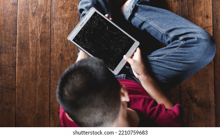 Top View Of Kid Sad Face, Unhappy Child Sitting Holding  Broken Tablet Computer, Emotion Sad And Sad Face, Depressed Children Concept