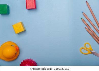 Top View Of Kids Background With Toys On White. Wooden Cubes, Colorful Toy Bricks, Pencils, Magnifying Glass On Blue Background. Educational Toys For Preschool, Kindergarten Or Daycare. Kid's Dream