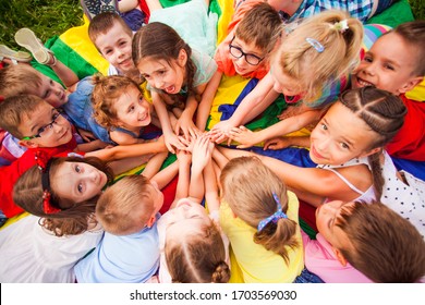 Top view kids in circle laying on colorful cloth - Powered by Shutterstock