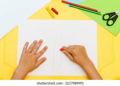 Top view of kid's hands paiting with crayons. Indoor activity