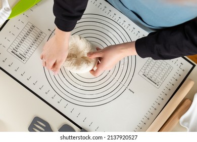 Top View Of Kneading Dough On Rubber Kitchen Mat On Kitchen Table.