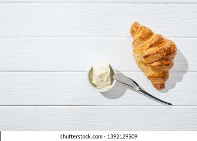 Top View Of Knife Near Bowl With Cream Cheese And Croissant On White  