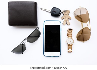 Top View Of Lady Set: Watches, Car Keys, Sunglasses,and Smartphone On White Background
