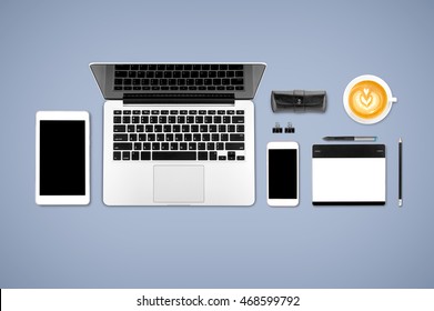 Top view laptop computer with mobile phone, cop of coffee, tablet, pencil and graphic tablet on office desk table.Business template mock up for adding your text.