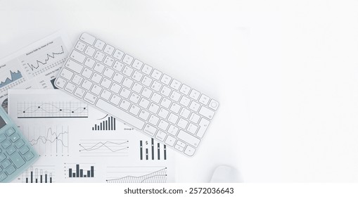 Top view of a laptop computer, a notebook for notes and a calculator on a white table with a place to copy