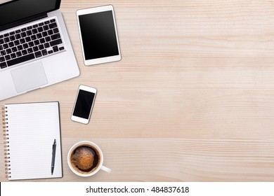 Top view laptop computer or notebook,mobile phone and cup of  coffee on wooden table. Business template mock up for adding your text.
