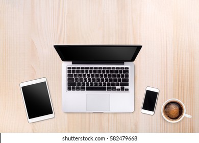 Top view laptop computer or notebook,mobile phone and cup of coffee on wooden table. Business template mock up for adding your text.
