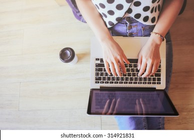 Top view of laptop in girl's hands sitting on a wooden floor with coffee, work from home or cafe 
 - Shutterstock ID 314921831
