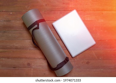 Top View Of Laptop And Gray Yoga Mat In Studio. Sports Concept