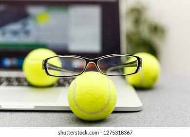 Top View Of Laptop, Sports Equipment, Tennis Ball, Glasses On The Sports Administration White Table.Business Concept.