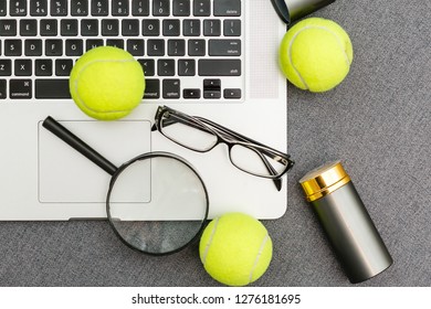 Top View Of Laptop, Sports Equipment, Tennis Ball, Shuttlecock, Glasses Aon The Sports Administration Gray Table.Business Concept.