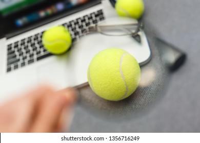 Top View Of Laptop, Sports Equipment, Tennis Ball, Shuttlecock, Glasses Aon The Sports Administration Gray Table.Business Concept.