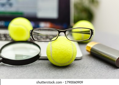 Top View Of Laptop, Sports Equipment, Tennis Ball, Glasses On The Sports Administration White Table.Business Concept.