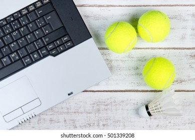 Top View Of Laptop, Sports Equipment, Tennis Ball And Shuttlecock On The Sports Administration White Table.Business Concept.