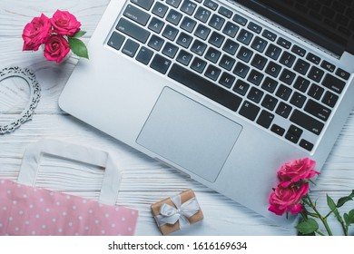 Top View Of Laptop And St. Valentine's Day Decorations, Paper Gift Bag And Rose Flowers.  Flatlay Background. Online Shopping, Holiday Sale Concept.