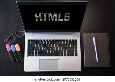 Top view of laptop with text HTML5. Html5 inscription on laptop screen and keyboard. Learn html language, computer courses, training. 